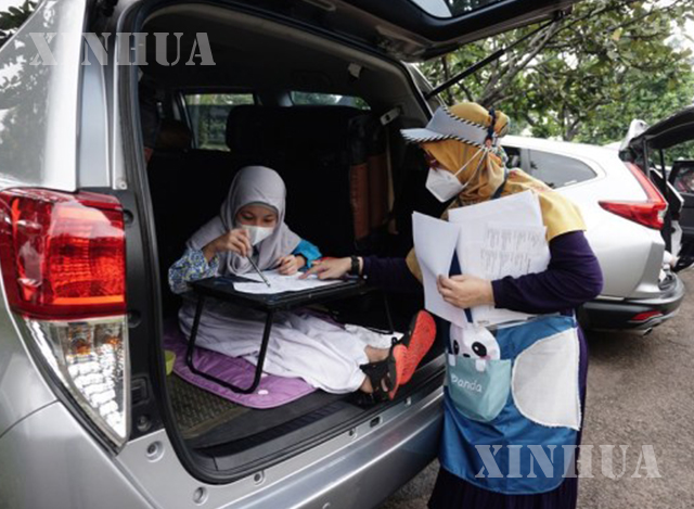 အင်ဒိုနီးရှာနိုင်ငံ ဂျကာတာမြို့၌ Drive-In Learning (DIL) အစီအစဉ်ဖြင့် ဧပြီ ၅ ရက်က မူလတန်း ကျောင်းသားများကို ဆရာများက မော်တော်ကားအတွင်း စာသင်ပေးနေစဉ် (ဆင်ဟွာ)