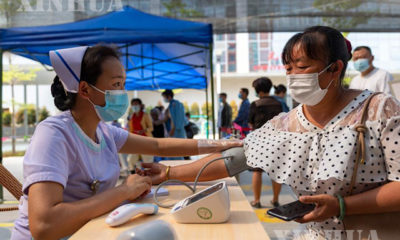 တရုတ်နိုင်ငံ ယူနန်ပြည်နယ် အနောက်တောင်ပိုင်း ရွှေလီမြို့ Jingcheng ဆေးရုံရှိ COVID-19 ကာကွယ်ဆေးထိုးနှံသောနေရာတစ်ခုတွင် အမျိုးသမီးတစ်ဦးအား သွေးပေါင်ချိန်ပေးနေသည်ကို တွေ့ရစဉ် (ဆင်ဟွာ)