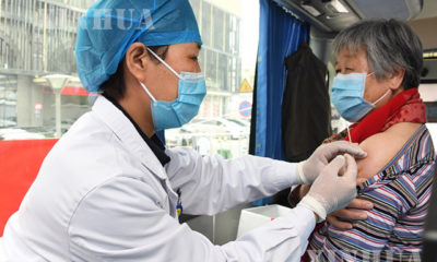 တရုတ်နိုင်ငံ ပေကျင်းမြို့၌ ရွေ့လျားကာကွယ်ဆေးထိုးနှံပေးသည့် ယာဉ်တစ်စီးပေါ်တွင် ကျန်းမာရေးဝန်ထမ်းတစ်ဦးက ဒေသခံတစ်ဦးအား ဧပြီ ၁၁ ရက်တွင် ကာကွယ်ဆေးထိုးနှံပေးနေစဉ်(ဆင်ဟွာ)