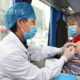 တရုတ်နိုင်ငံ ပေကျင်းမြို့၌ ရွေ့လျားကာကွယ်ဆေးထိုးနှံပေးသည့် ယာဉ်တစ်စီးပေါ်တွင် ကျန်းမာရေးဝန်ထမ်းတစ်ဦးက ဒေသခံတစ်ဦးအား ဧပြီ ၁၁ ရက်တွင် ကာကွယ်ဆေးထိုးနှံပေးနေစဉ်(ဆင်ဟွာ)